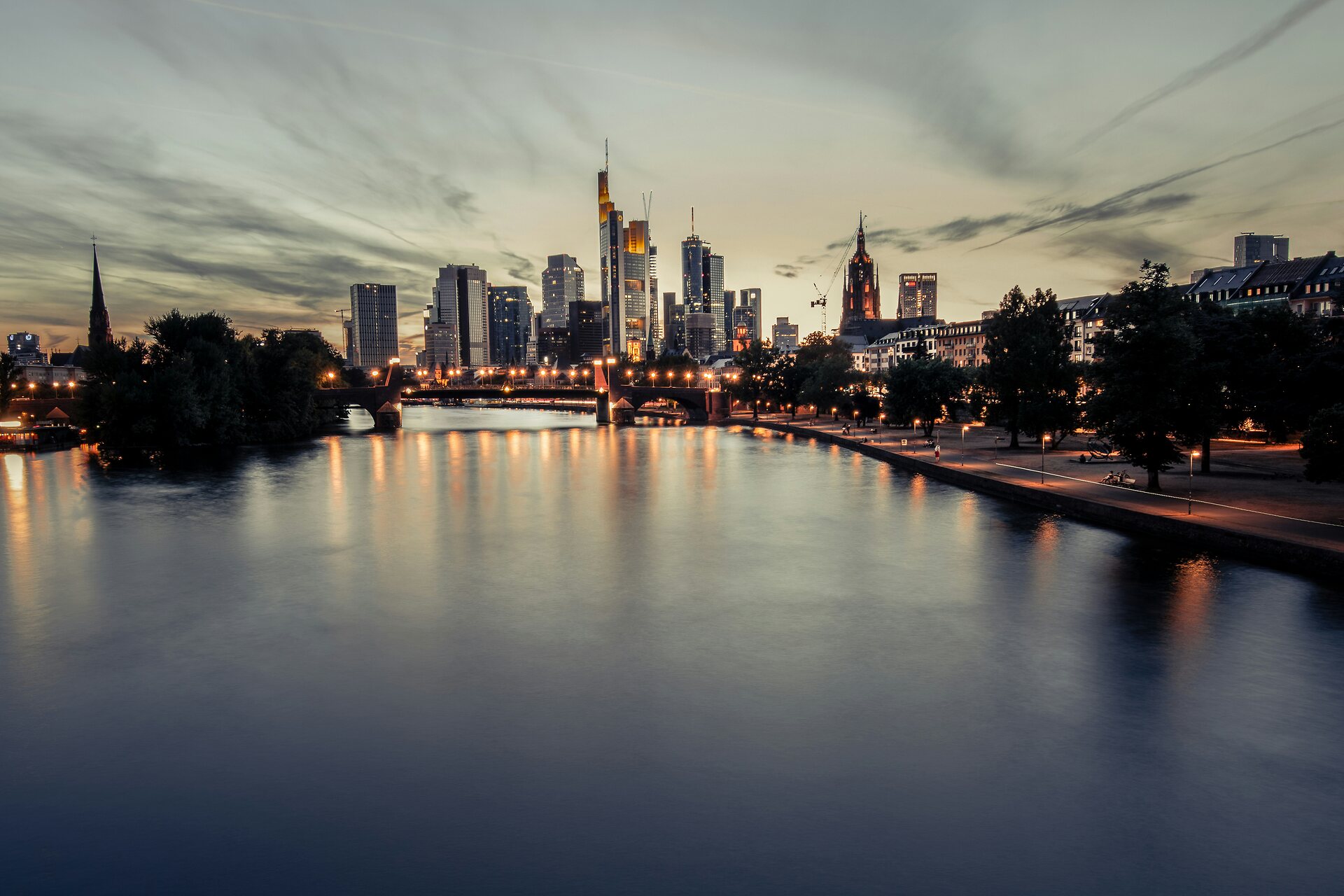 Beleuchtete Frankfurter Bankenskyline am Main in warmer Abenddämmerung